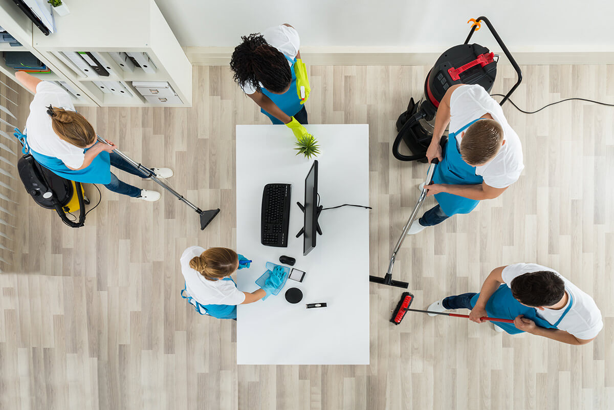 commercial cleaning team, women and men wearing blue aprons