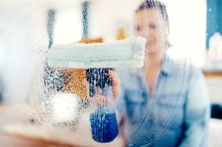 Staff cleaning the glass window using window wiper